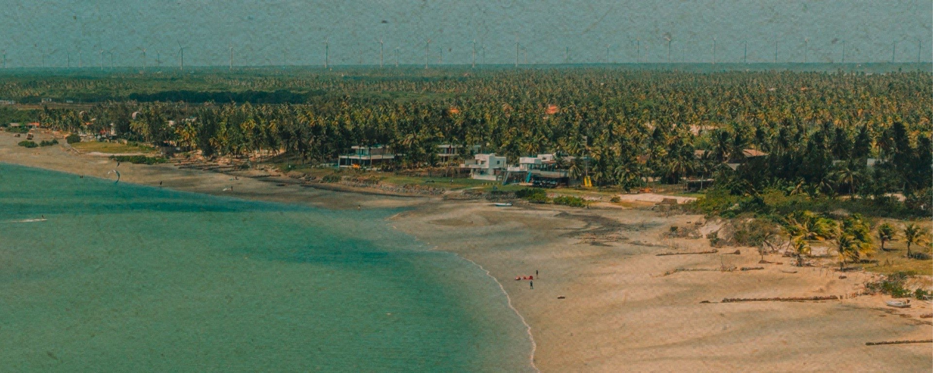 Vista aérea da vila com restaurantes, pousadas e coqueiral na Ilha do Guajiru